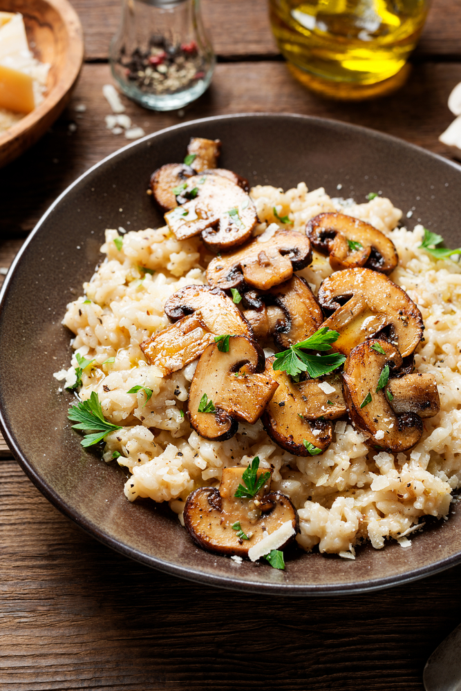 Close up of vegan mushroom risotto in a brown bowl.