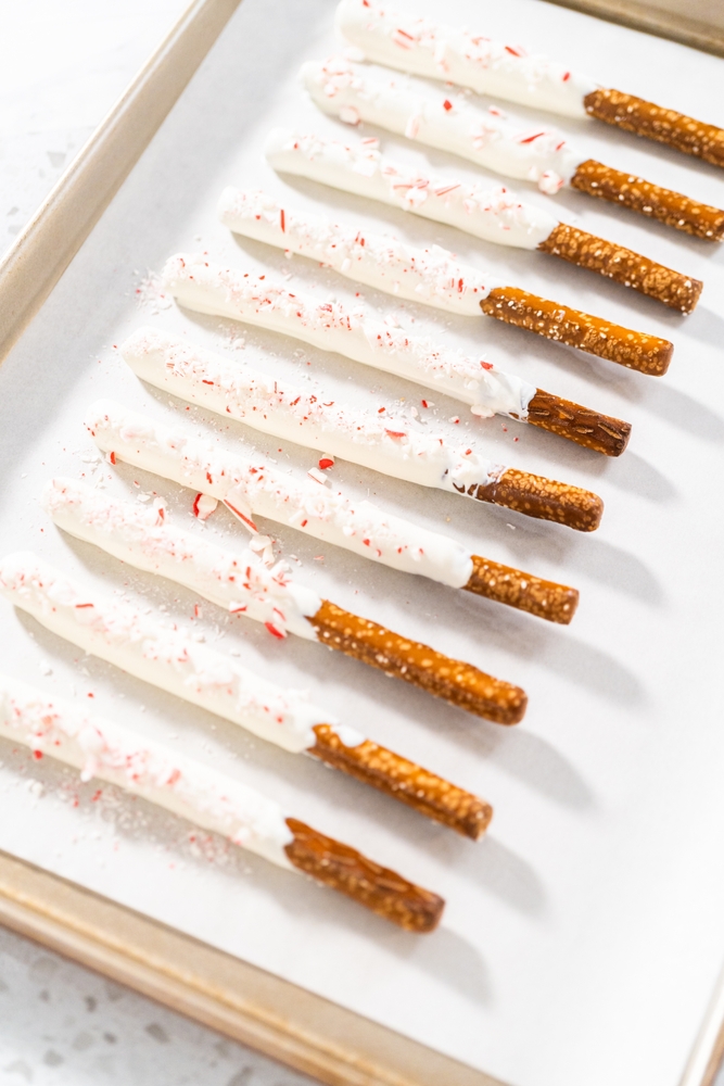 Line of Candy Cane Pretzels on parchment paper on a baking sheet.