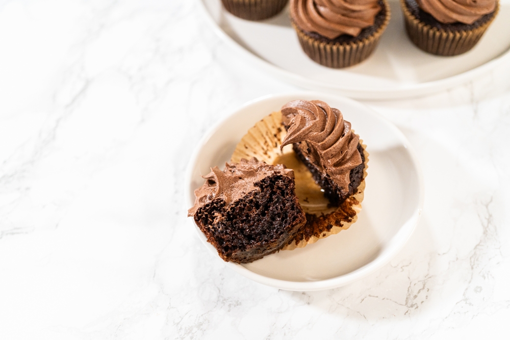 A delectable chocolate cupcake, sliced in half, elegantly presented on a plate.