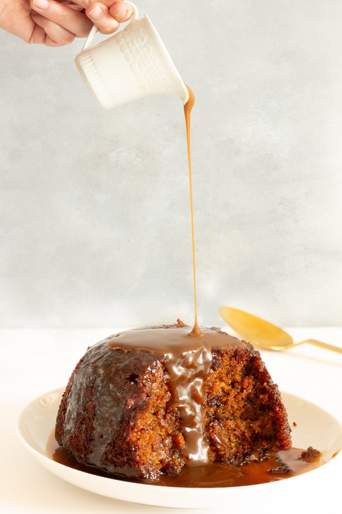 Sticky toffee pudding with the sauce been poured on perfect for a vegan Christmas dinner 