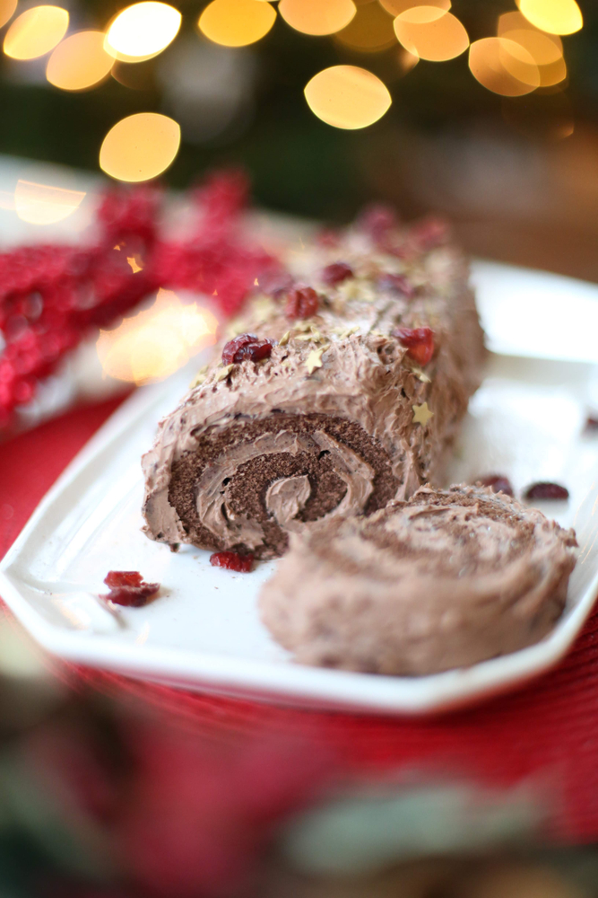 Vegan yule log with choclote coating and berries on 