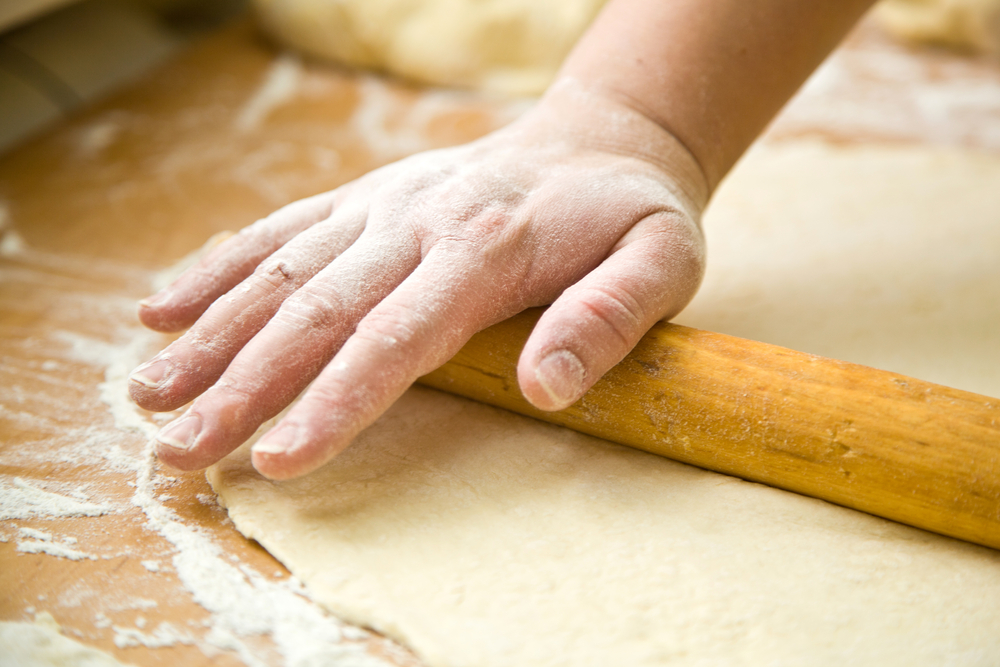 hand with rolling pin and flour