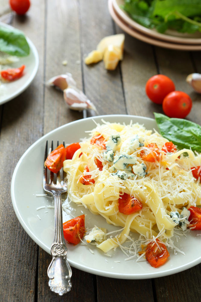 pasta with brie cheese and roasted tomatoes, food close up.