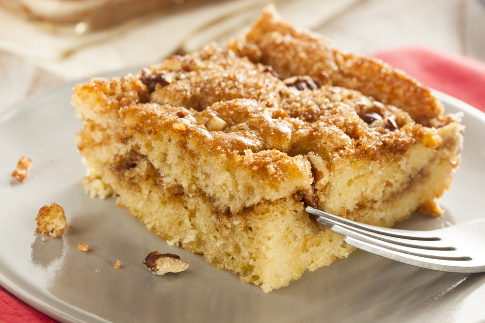 Homemade Coffee Cake with Cinnamon and Nuts. It is on a plate with a fork next to it. 