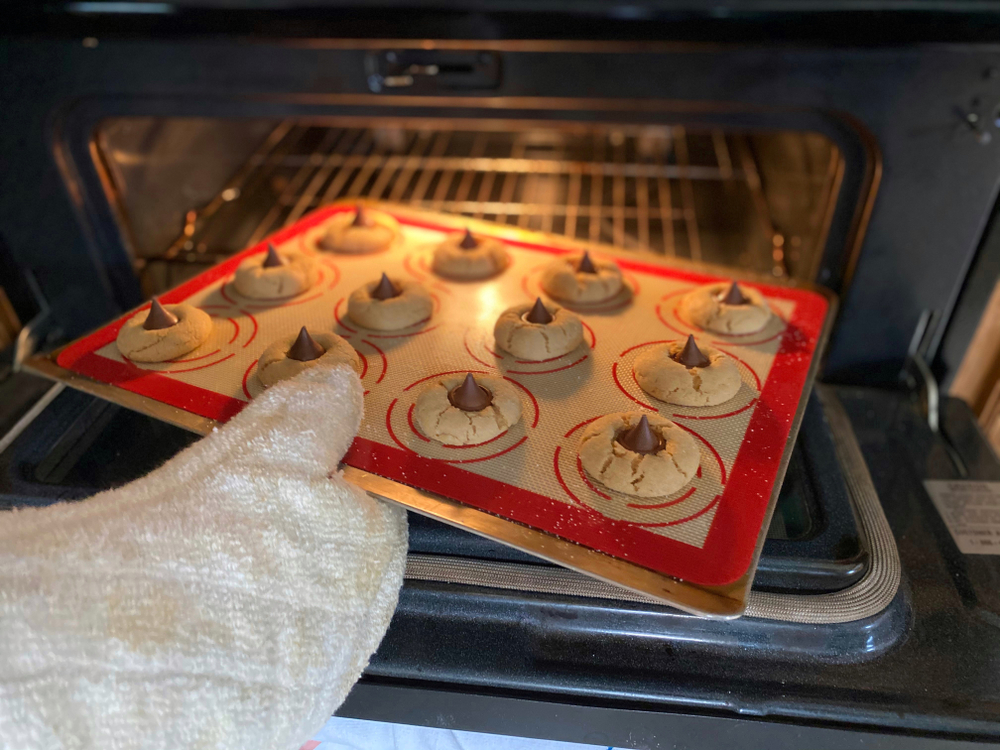 Putting Christmas cookies out of the oven. 