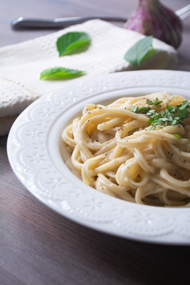 Creamy vegan Alfredo pasta topped with parsley and black pepper.
