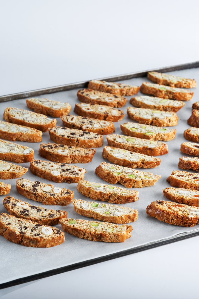 Different variations of biscotti on a baking sheet. 