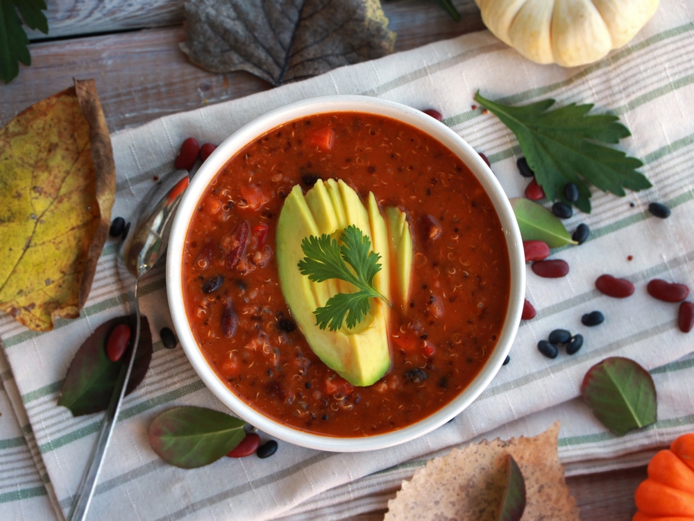 Bowl of vegetarian chilli topped with avacado 