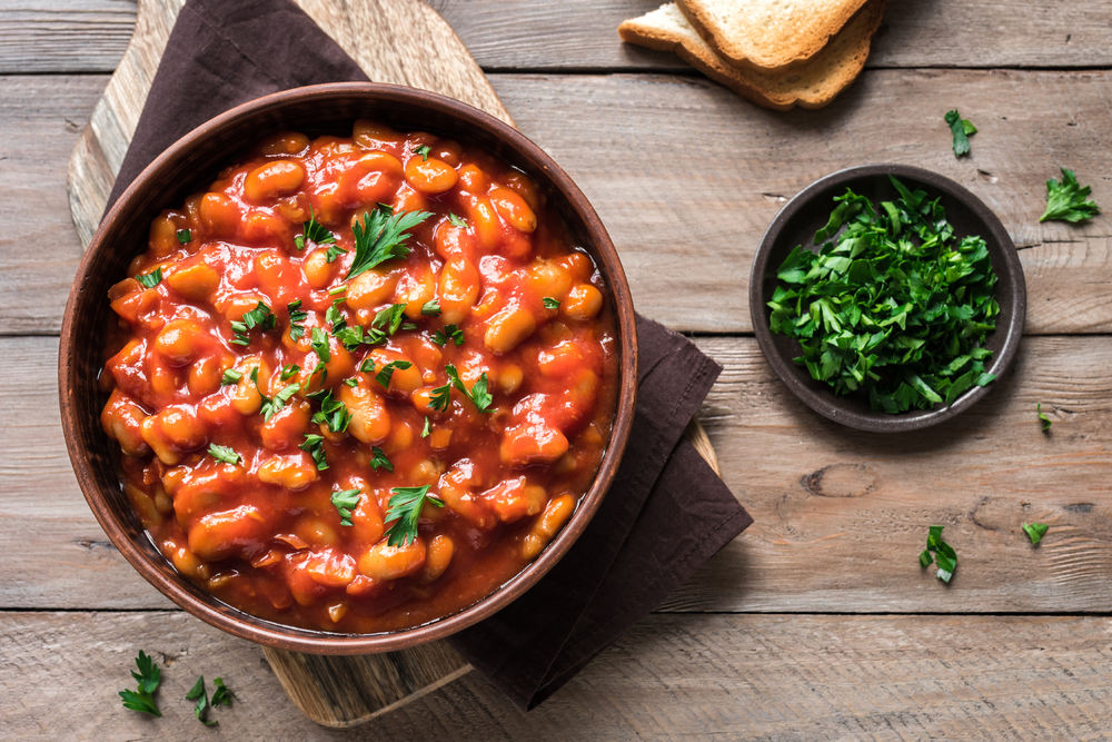 Bean chili thick and hearty on table with cilantro next to it. 