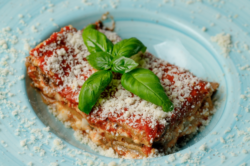 Traditional Italian cuisine vegetarian lasagna with eggplant tomato sauce, basil, garlic and cheeses - parmigiana  