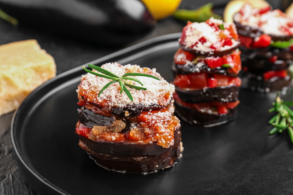Tray with tasty baked Eggplant Parmesan on table, closeup