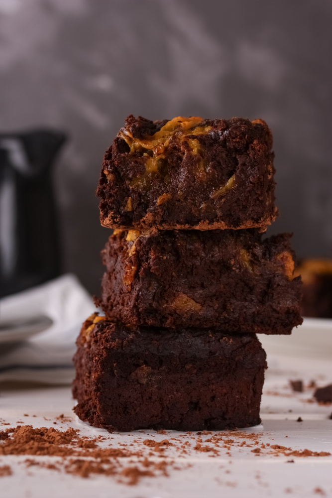 
Pieces of chocolate brownie with pumpkin cream drizzled on 