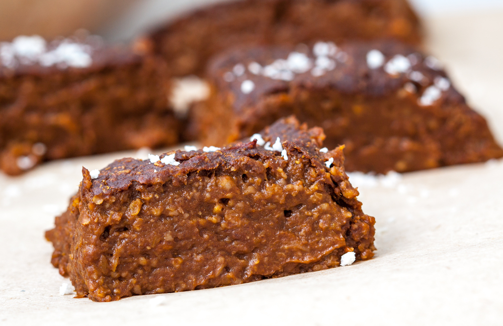 Pumpkin vegan brownie. gooey centre can be seen. There are several on a plate. 