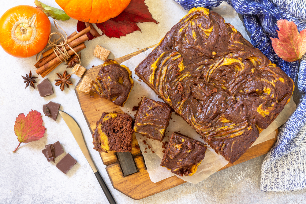 Chocolate brownie pumpkin puree cake dessert with spices on a stone table. Top view flat lay background.