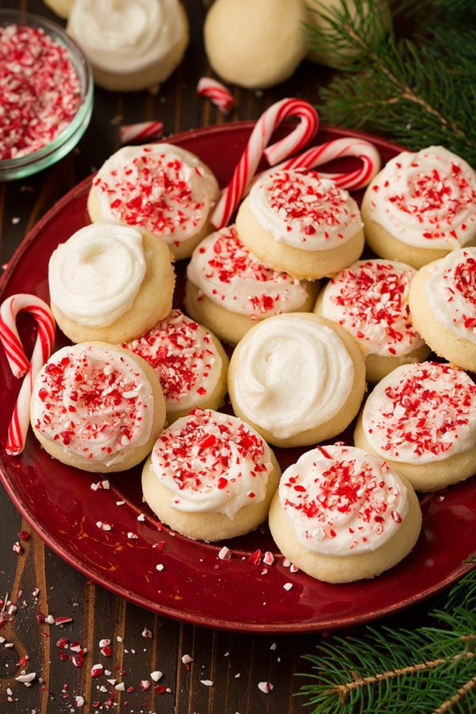 Peppermint Snickerdoodles on a plate with candy canes crushed on tip and fir in the background. 