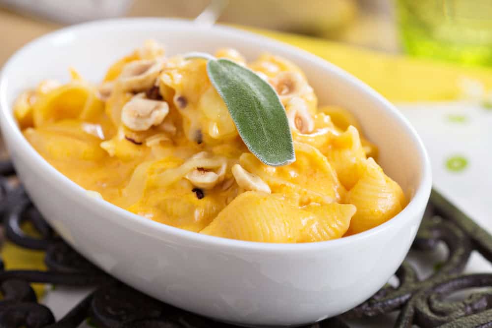 Macaroni and cheese with butternut squash and sage in a white bowl