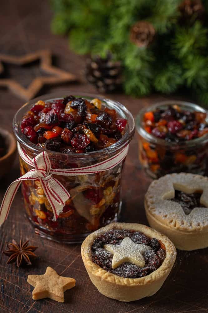 Christmas fruit mincemeat and mince pies, wooden background. The article is about vegan mince pies