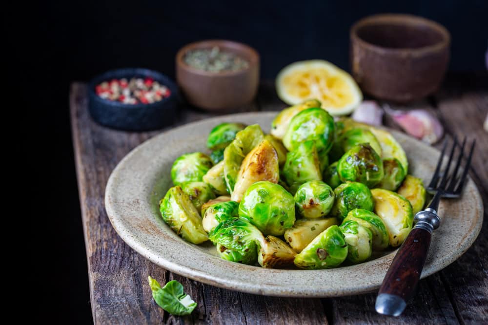 Homemade Roasted Brussel Sprouts with olive oil, salt, lemon and pepper. The article is a vegan brussels sprouts recipe.