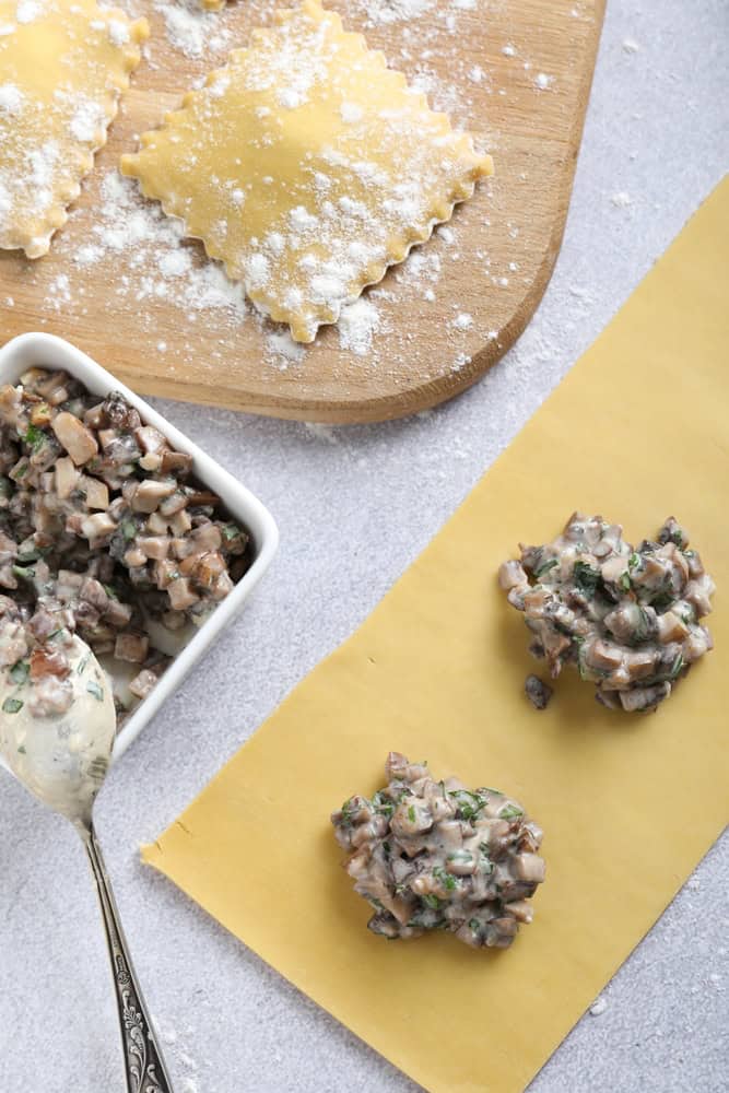 Making ravioli with mushrooms at light table, flat lay. The article is about vegan pasta